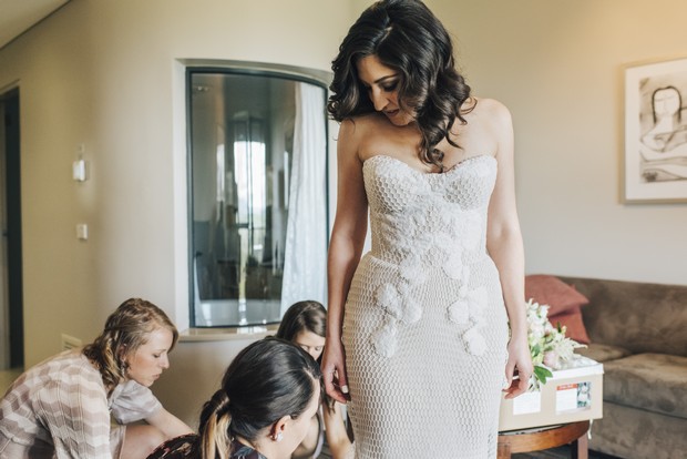 bridesmaid-fixing-bride's-wedding-dress